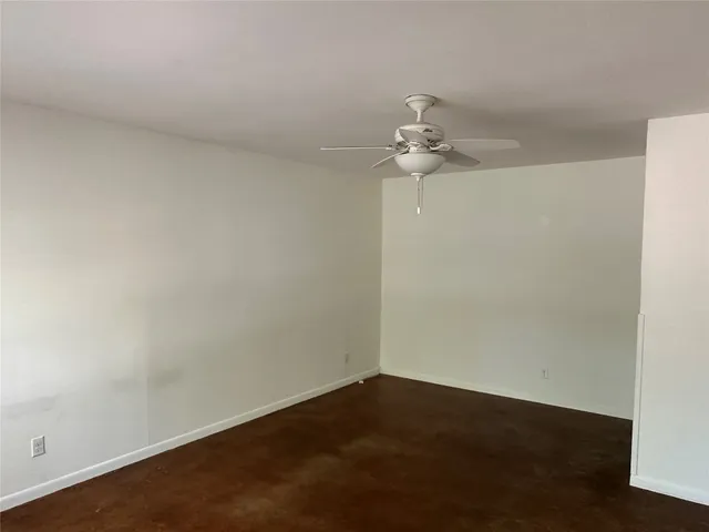 an empty room with a window and a ceiling fan