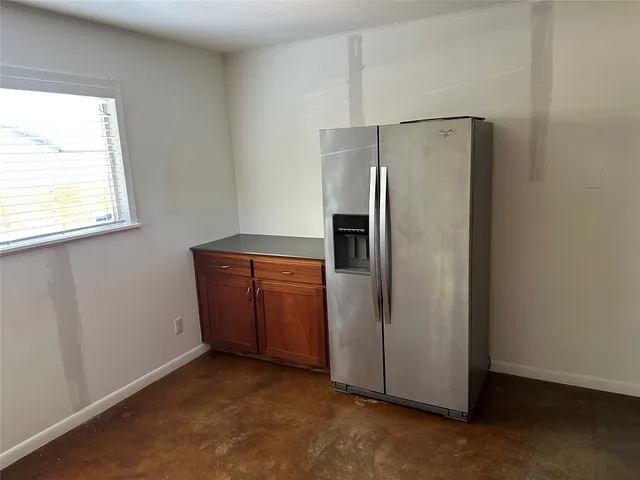a view of a kitchen with a refrigerator cabinet and window