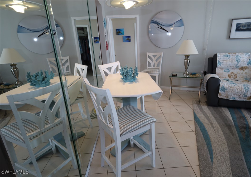 58 North Collier Boulevard, Unit 1103 Marco Island, FL 34145 - Photo 4 of 19 a living room with furniture a mirror and a lamp