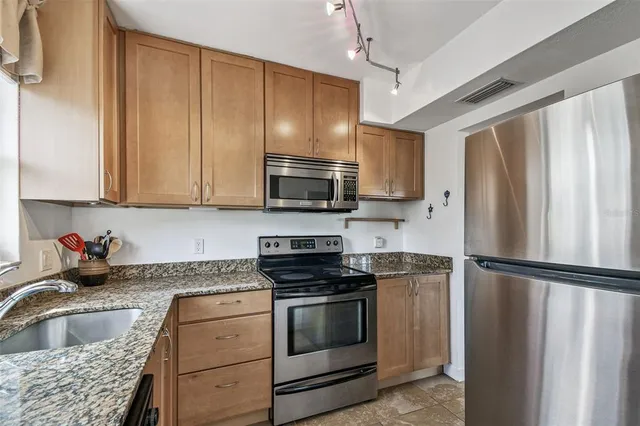 a kitchen with stainless steel appliances granite countertop a sink and a window