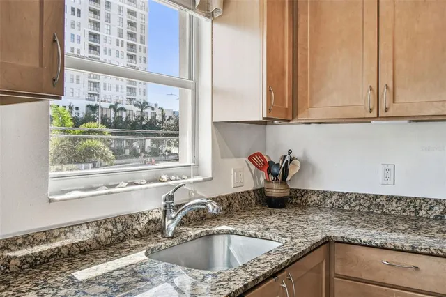 a kitchen with granite countertop a sink stove and cabinets