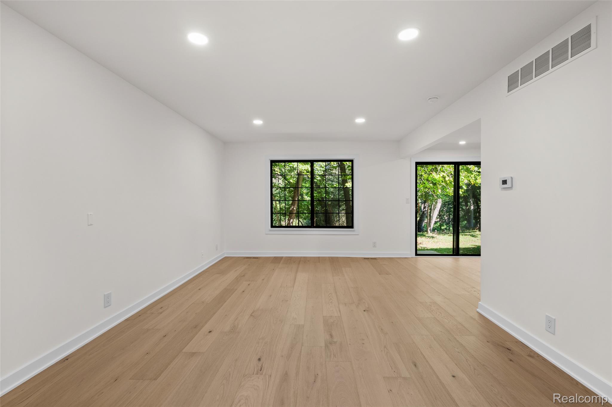 1830 Streamedge Court Rochester, MI 48309 - Photo 6 of 33 Recessed lighting, wood-finish flooring, white walls, black-framed windows, and a glass-paneled door
