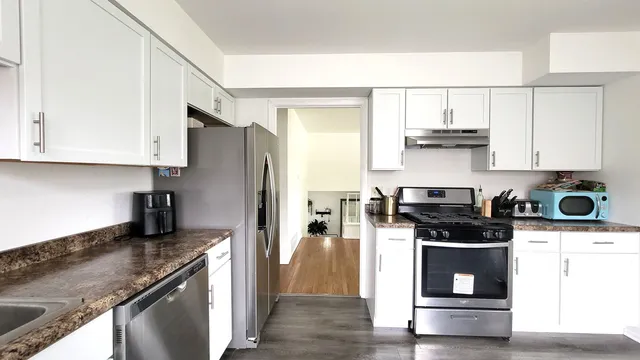 a kitchen with stainless steel appliances granite countertop a stove a refrigerator and a sink