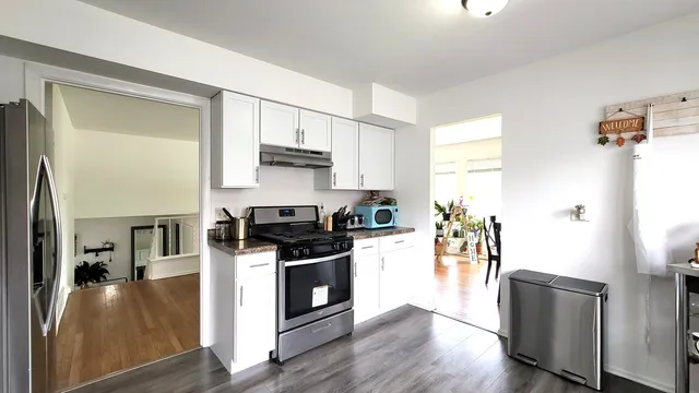 a kitchen with stainless steel appliances a stove a sink and a refrigerator