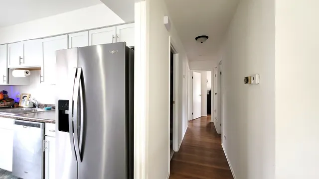 a view of a refrigerator in kitchen and a window