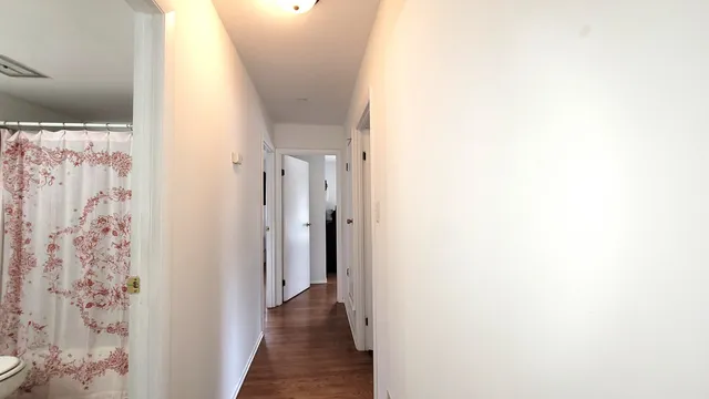 a view of a hallway with wooden floor