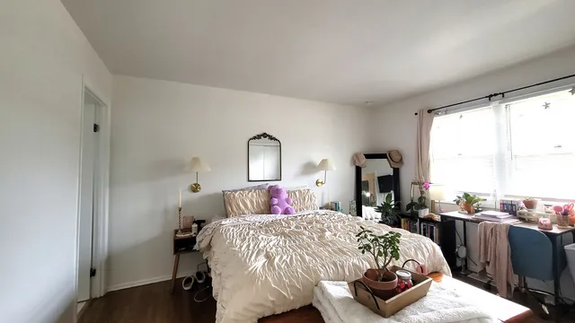 a bedroom with a bed and wooden floor