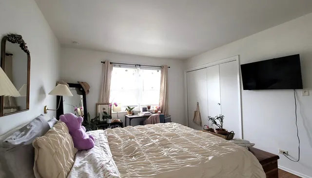 a bedroom with a bed a television and a window