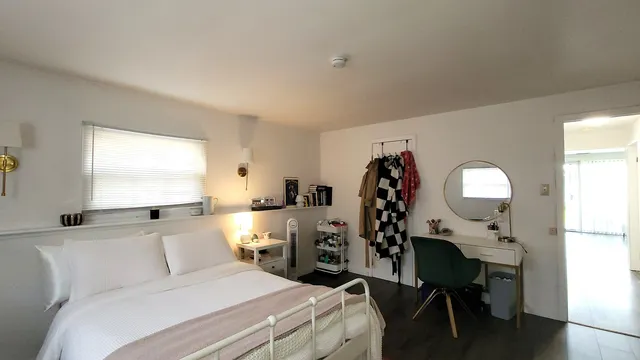 a bedroom with a bed window table and chair