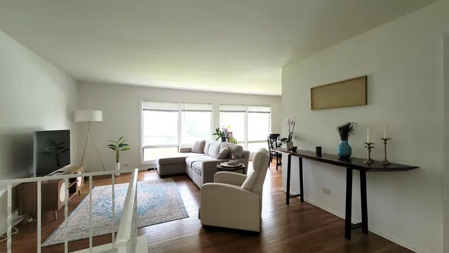 a living room with furniture a flat screen tv and wooden floor