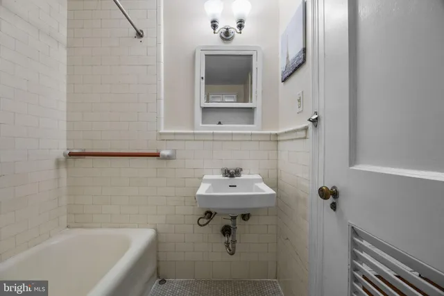 a bathroom with a sink a mirror and bathtub