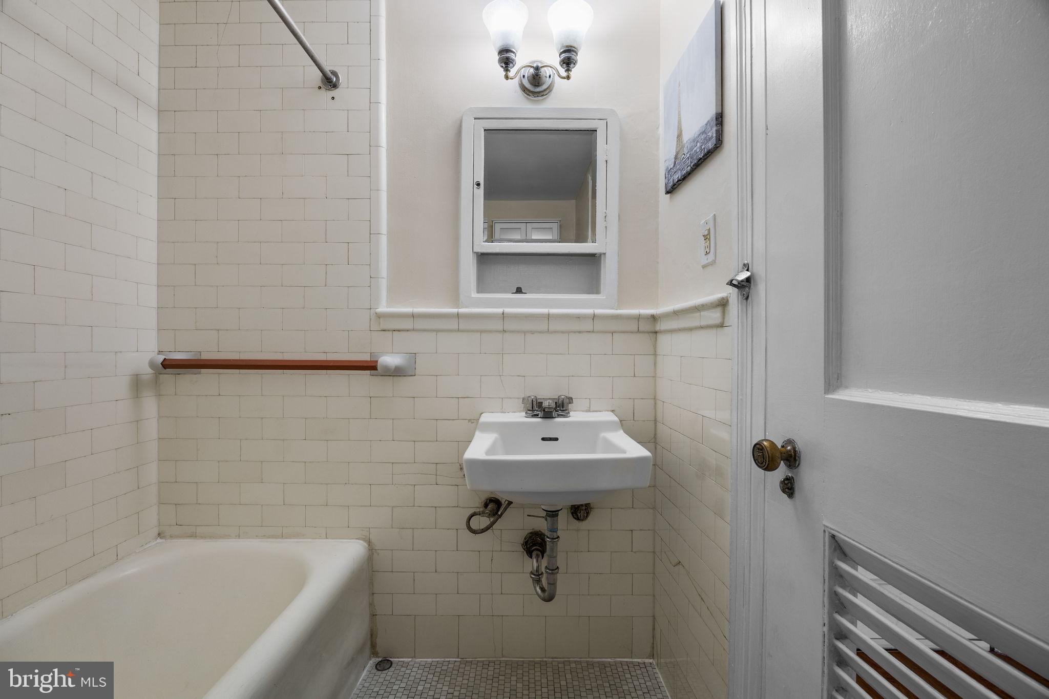 1324 Locust Street, Unit 807 Philadelphia, PA 19107 - Photo 13 of 36 a bathroom with a sink a mirror and bathtub
