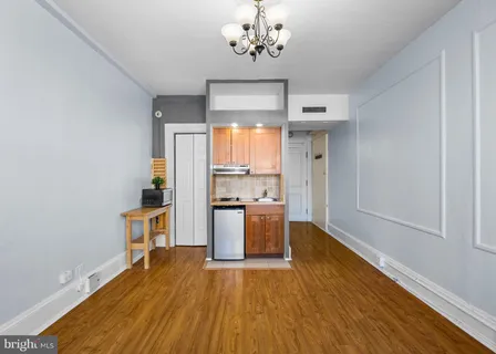 a kitchen with stainless steel appliances wooden floor and chandelier
