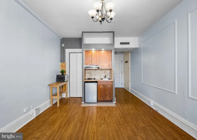 a kitchen with stainless steel appliances wooden floor and chandelier
