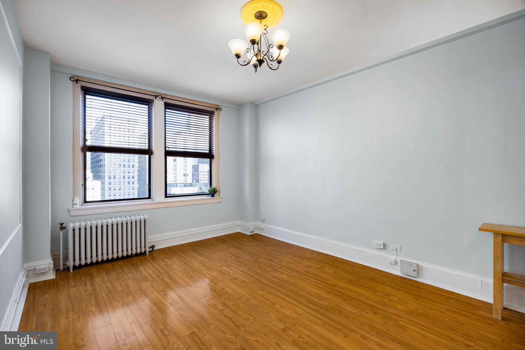 1324 Locust Street, Unit 807 Philadelphia, PA 19107 - Photo 20 of 36 a view of an empty room with window and wooden floor