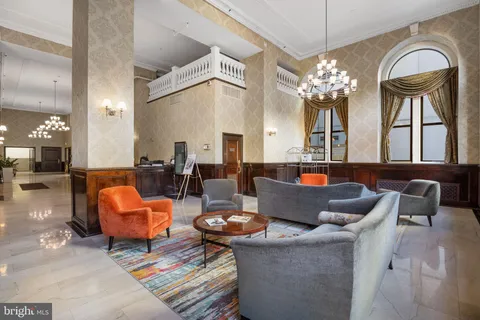 a living room with fireplace furniture and a chandelier