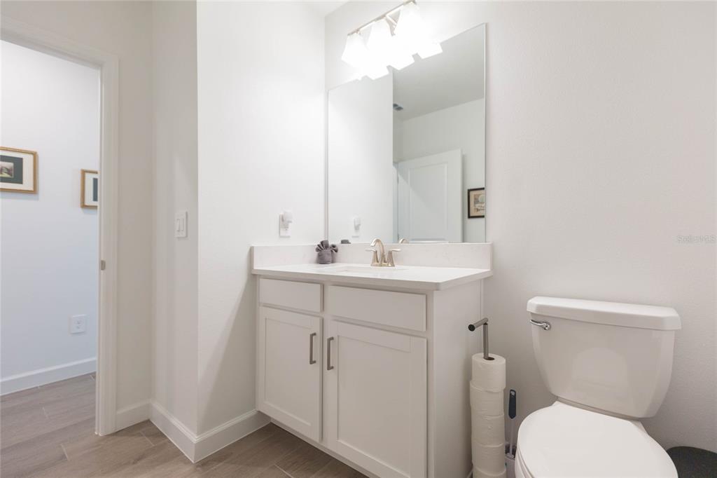 10806 Gable Dig Loop San Antonio, FL 33576 - Photo 37 of 73 a bathroom with a toilet sink and mirror