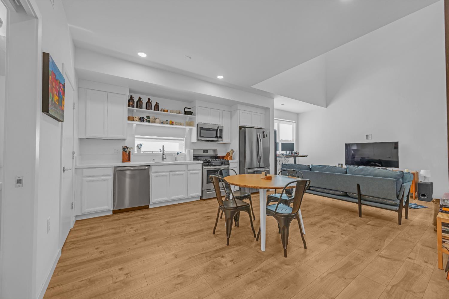2431 Cleat Lane, Unit 301 Sacramento, CA 95818 - Photo 7 of 18 a kitchen with a table chairs refrigerator and a sink