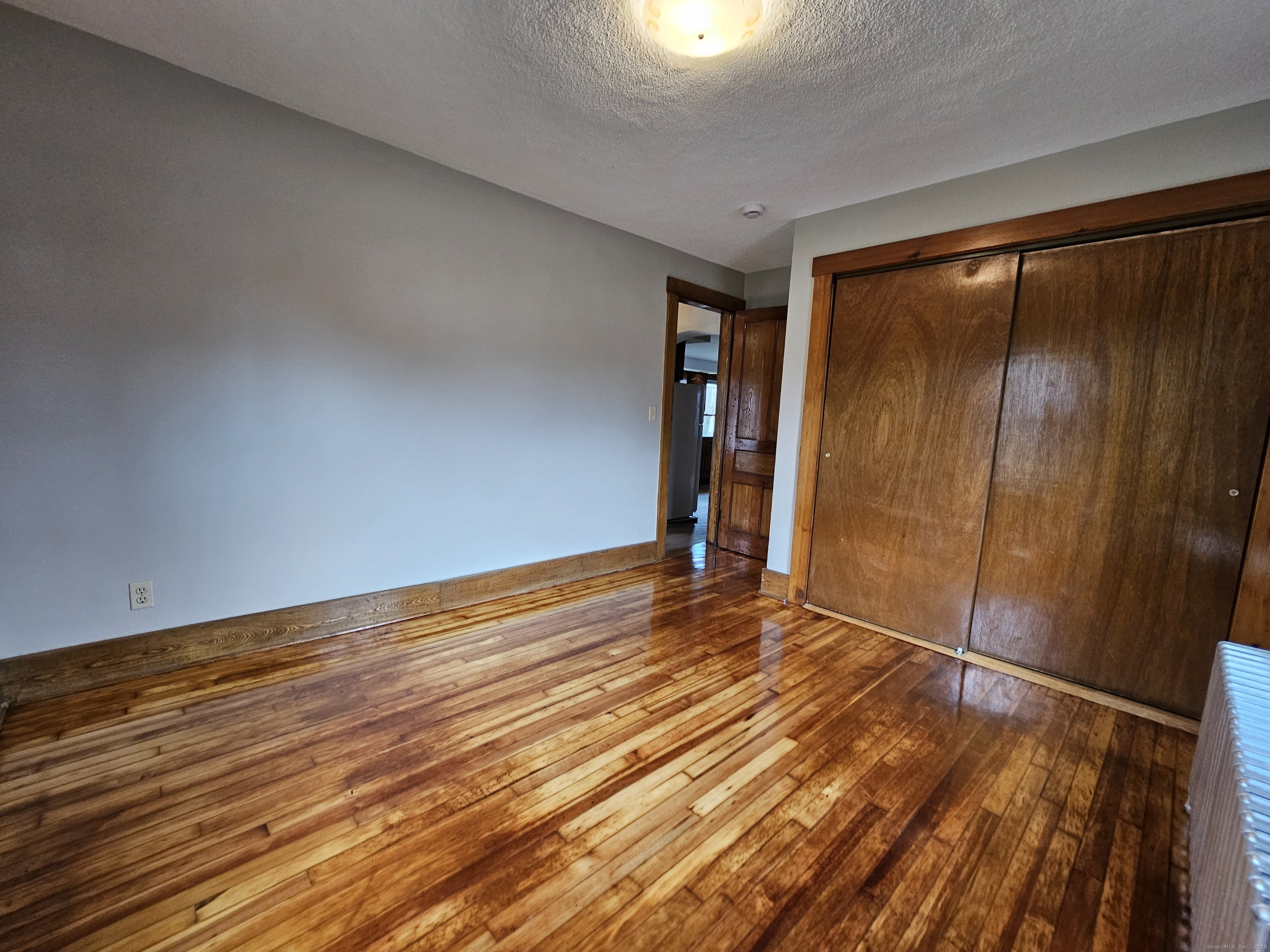 581 Center Street, Unit 1 Wallingford, CT 06492 - Photo 11 of 14 a view of an empty room with wooden floor and a window