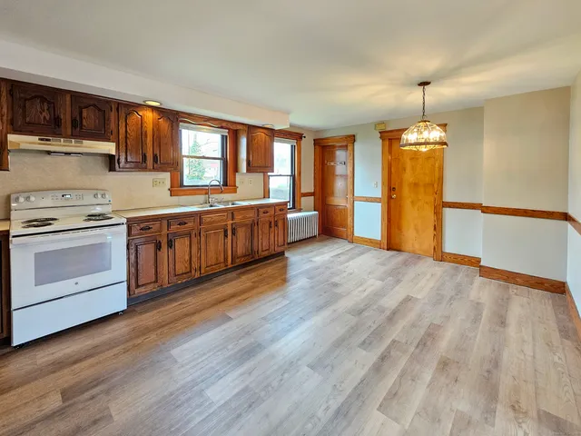 a large kitchen with wooden floors and stainless steel appliances