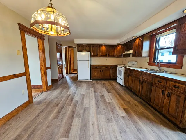 a kitchen with stainless steel appliances a stove cabinets and wooden floor