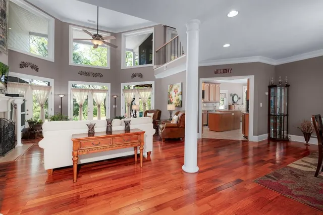 a kitchen with stainless steel appliances granite countertop a stove top oven a refrigerator a sink dishwasher a dining table and chairs with wooden floor