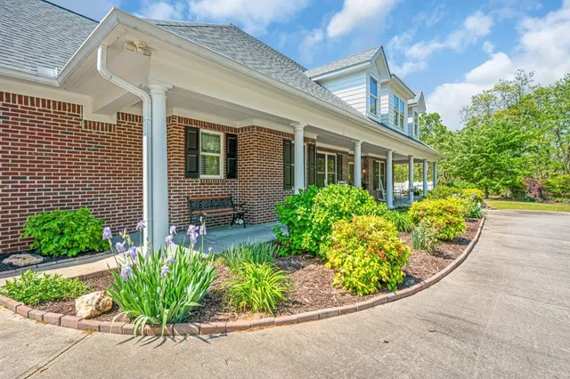 a porch with a bench next to a yard