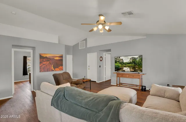 a living room with furniture a chandelier and a flat screen tv