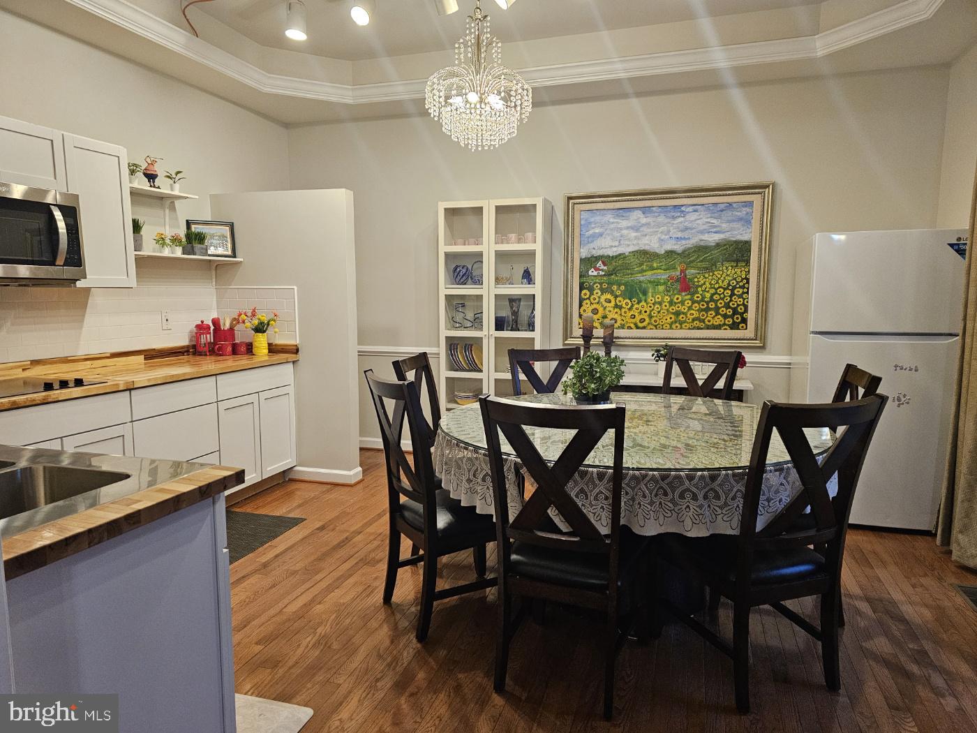 a view of a dining room with furniture a kitchen and chandelier