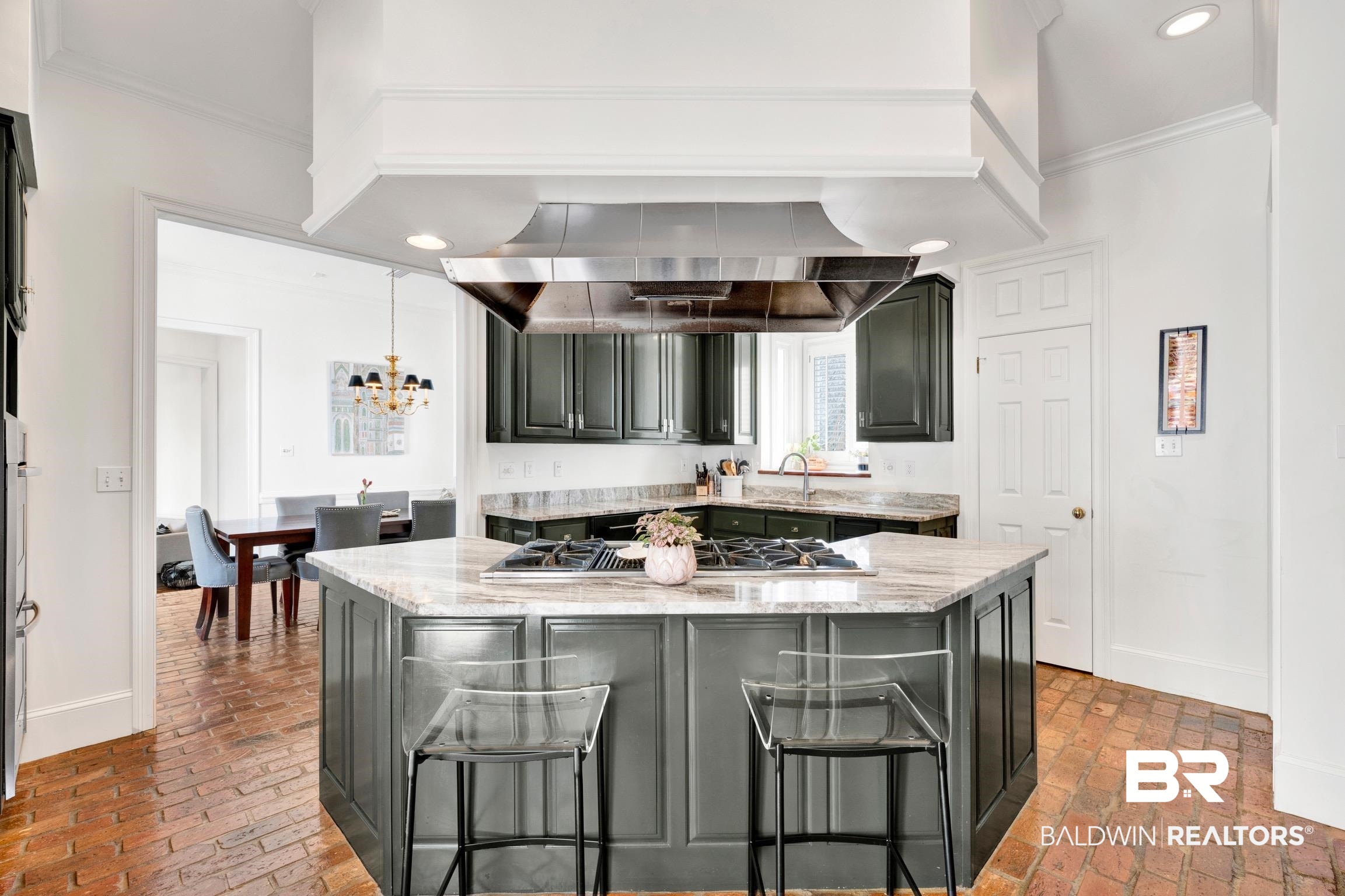 4 Savannah Court Mobile, AL 36608 - Photo 11 of 32 Kitchen with a center island, light stone counters, brick flooring, recessed lighting, and a breakfast bar area