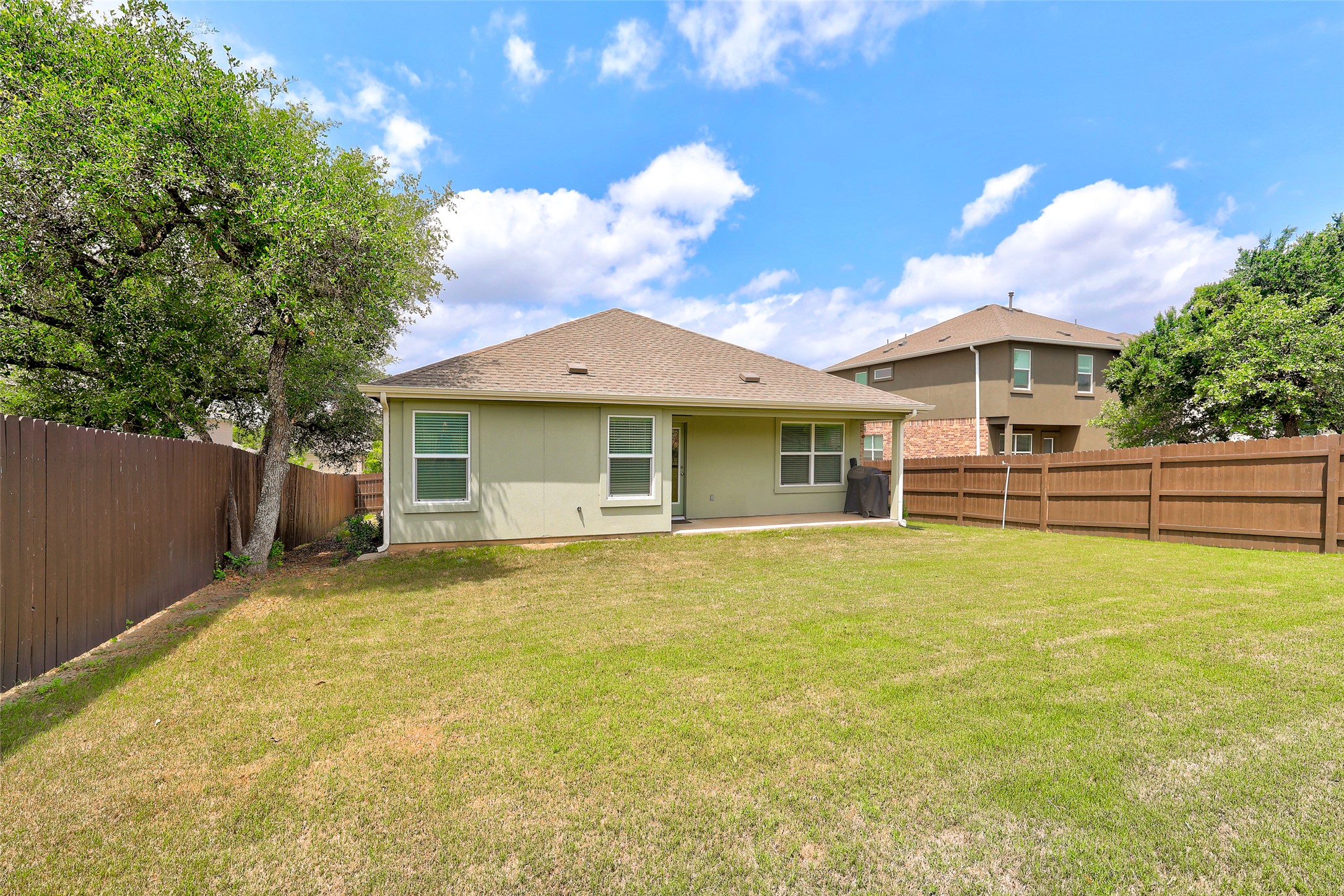 2333 Four Waters Loop Georgetown, TX 78628 - Photo 34 of 35 Expansive private backyard featuring a full perimeter privacy fence, mature trees, and a concrete patio