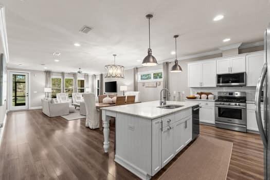 48 Barefoot Cove Freeport, FL 32439 - Photo 18 of 82 a kitchen with stainless steel appliances kitchen island granite countertop a stove top oven a sink dishwasher a dining table and chairs with wooden floor
