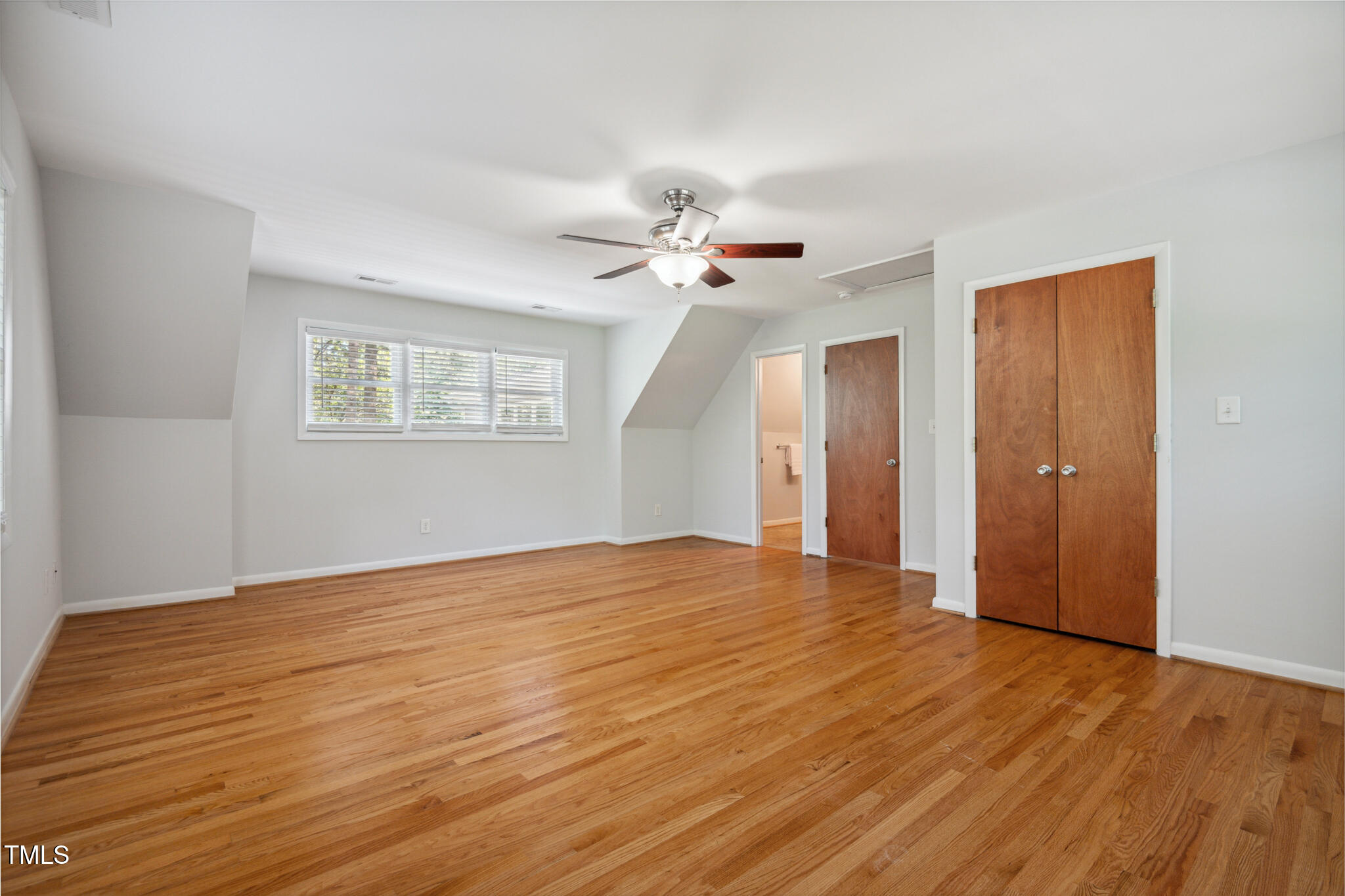 205 Northfield Drive Raleigh, NC 27609 - Photo 50 of 87 a view of an empty room with wooden floor and a ceiling fan
