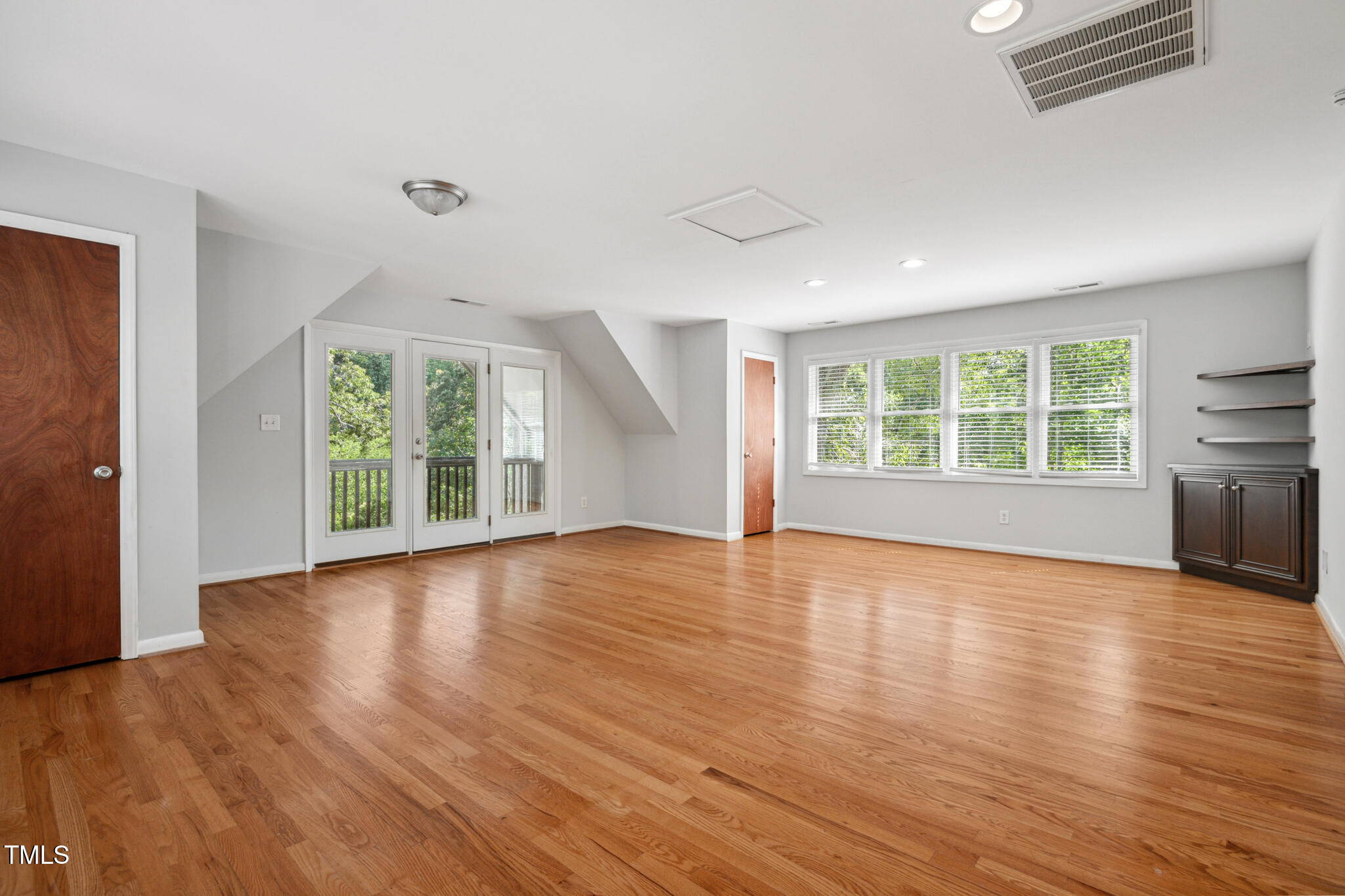 205 Northfield Drive Raleigh, NC 27609 - Photo 53 of 87 an empty room with wooden floor and windows