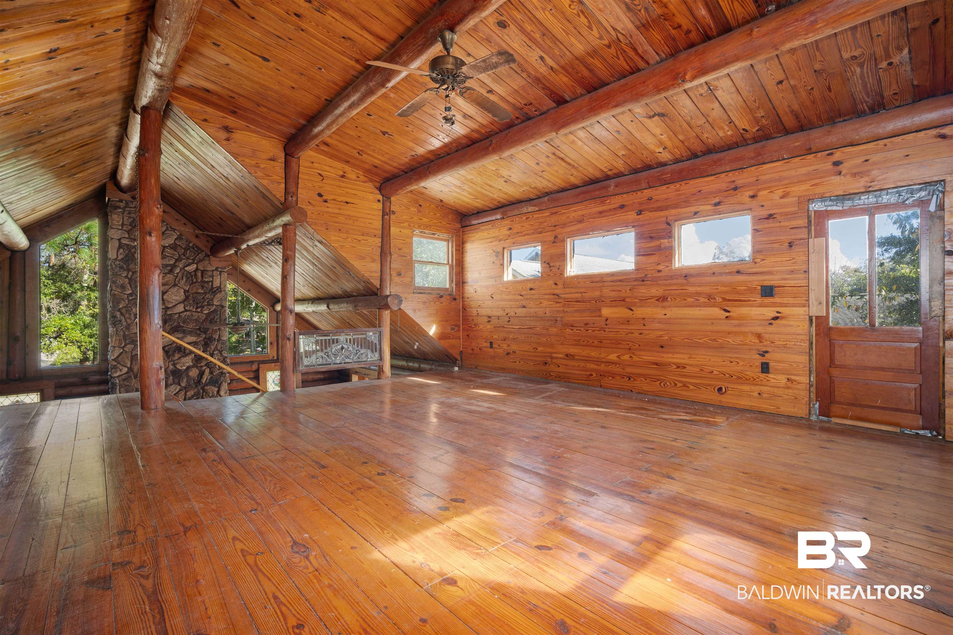11236 Wren Avenue Fairhope, AL 36532 - Photo 15 of 35 Unfurnished living room featuring wooden walls, wooden ceiling, hardwood / wood-style floors, and a ceiling fan