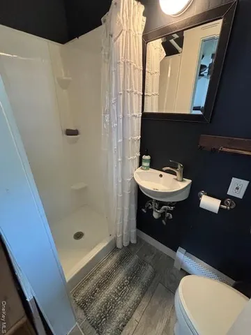 a bathroom with a sink a toilet and shower