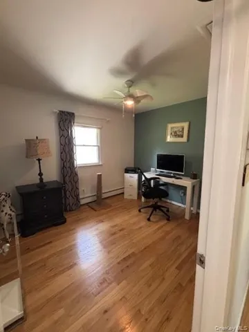 a view of a workspace with furniture and a window