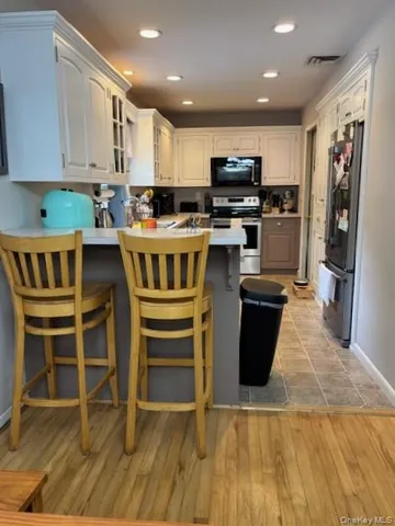 a kitchen with kitchen island granite countertop a stove top oven a sink and a microwave