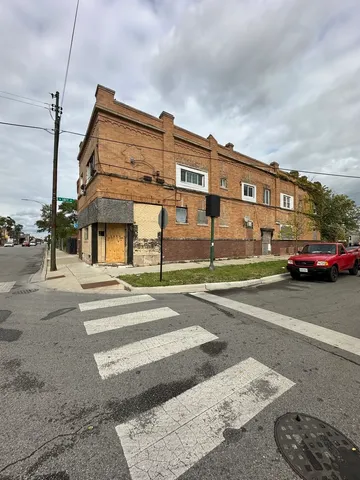 a view of a building and car parked on the road