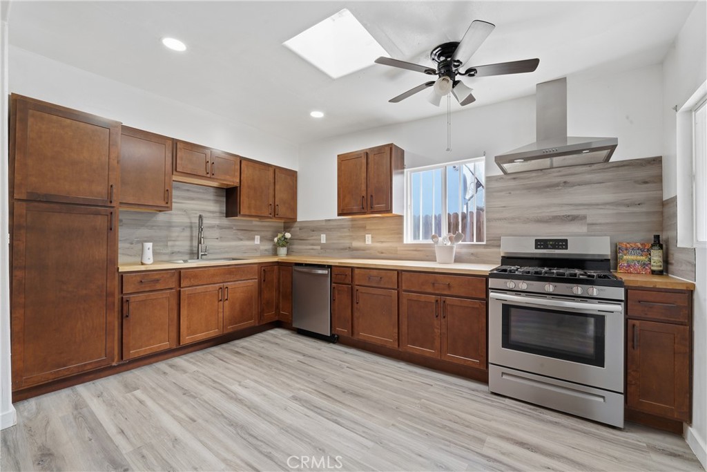 1724 East 10th Street Long Beach, CA 90813 - Photo 11 of 25 a kitchen with stainless steel appliances granite countertop a stove cabinets and refrigerator