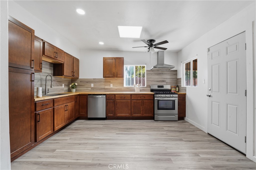 1724 East 10th Street Long Beach, CA 90813 - Photo 12 of 25 a large kitchen with stainless steel appliances and a stove top oven