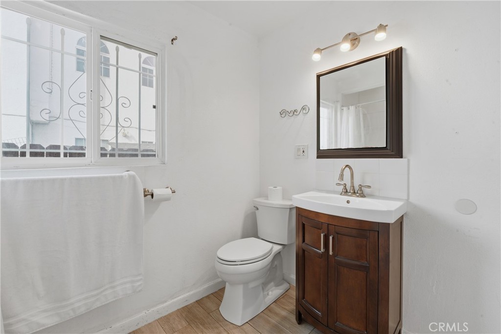 1724 East 10th Street Long Beach, CA 90813 - Photo 10 of 25 a bathroom with a toilet a sink and mirror