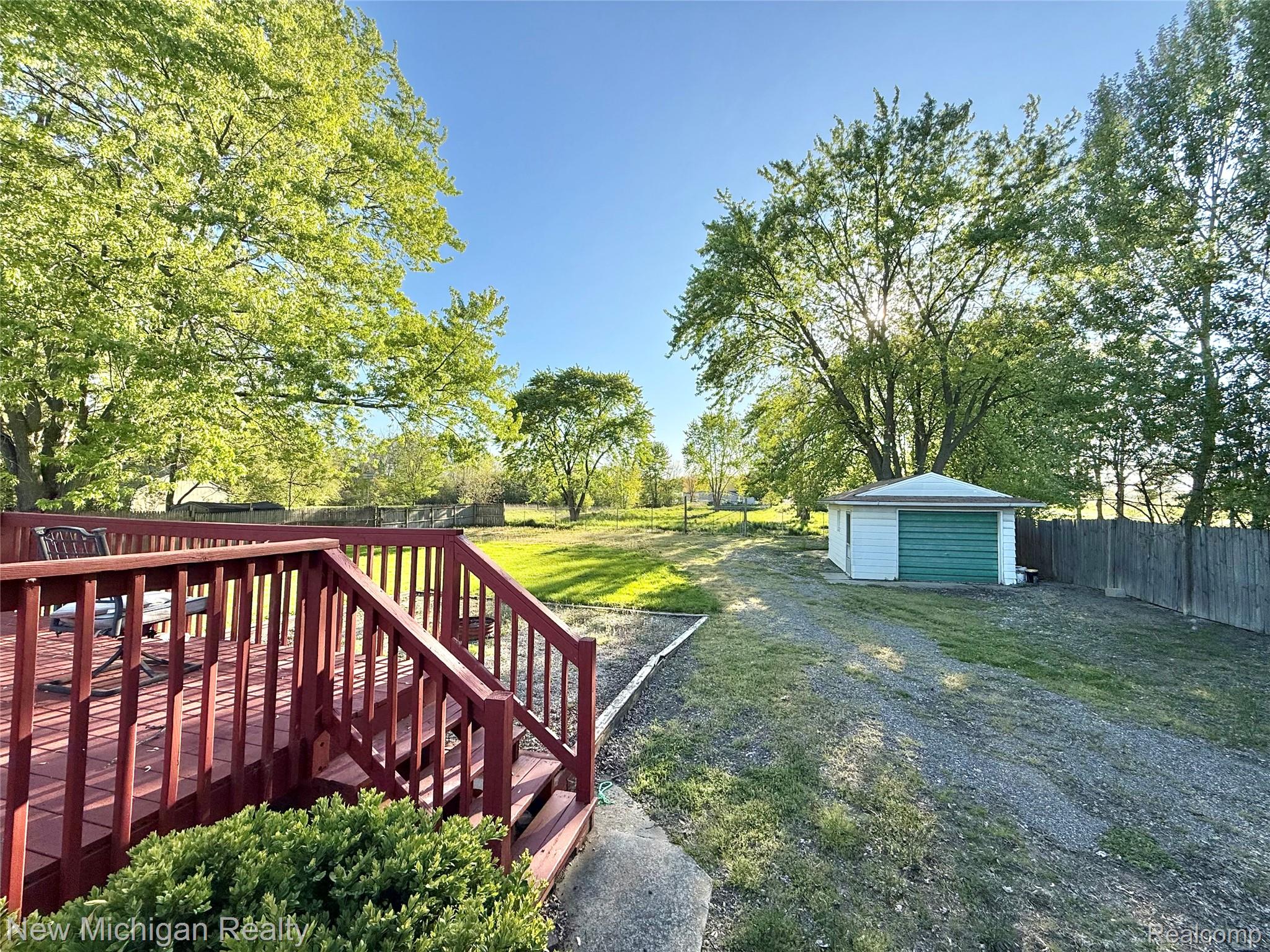 5288 Torrey Road Flint, MI 48507 - Photo 31 of 41 Fenced backyard with an outbuilding and a wooden deck