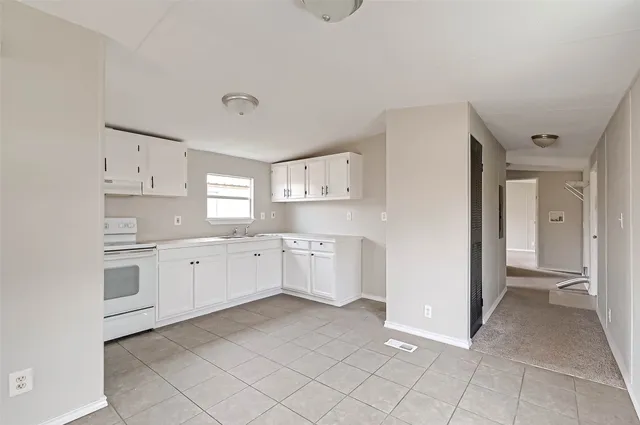 a large white kitchen with cabinets