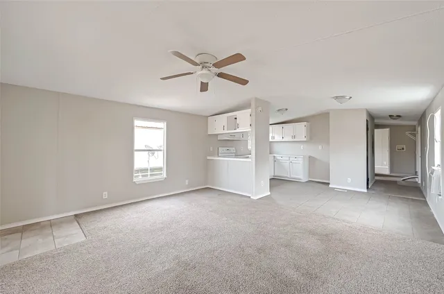 a view of a big room with windows and chandelier fan