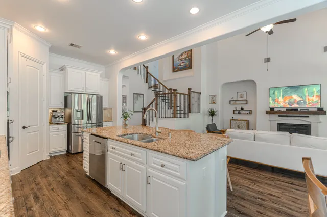 a dining hall with stainless steel appliances granite countertop a stove top oven a dining table and chairs with wooden floor