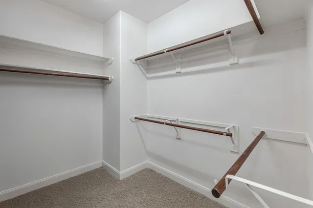 a view of staircase with lots of frames on wall and wooden floor