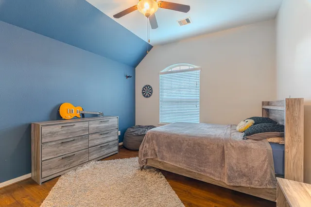 a bedroom with a bed and wooden floor