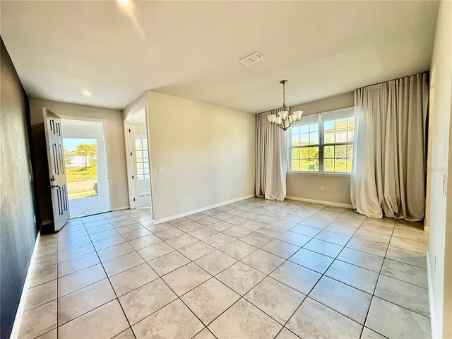 a kitchen with a dining table chairs and view of living room