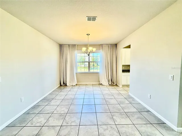 a kitchen with a dining table chairs and white appliances